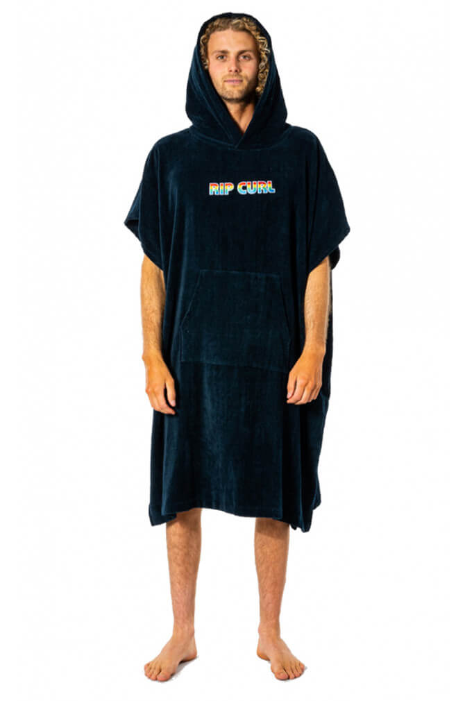 Mand med krøllet hår i navy badeponcho med et Rip Curl logo på brystet